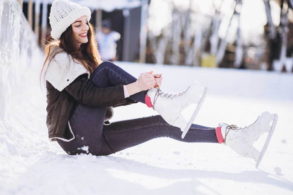 Young woman ice skating on a rink in a city center